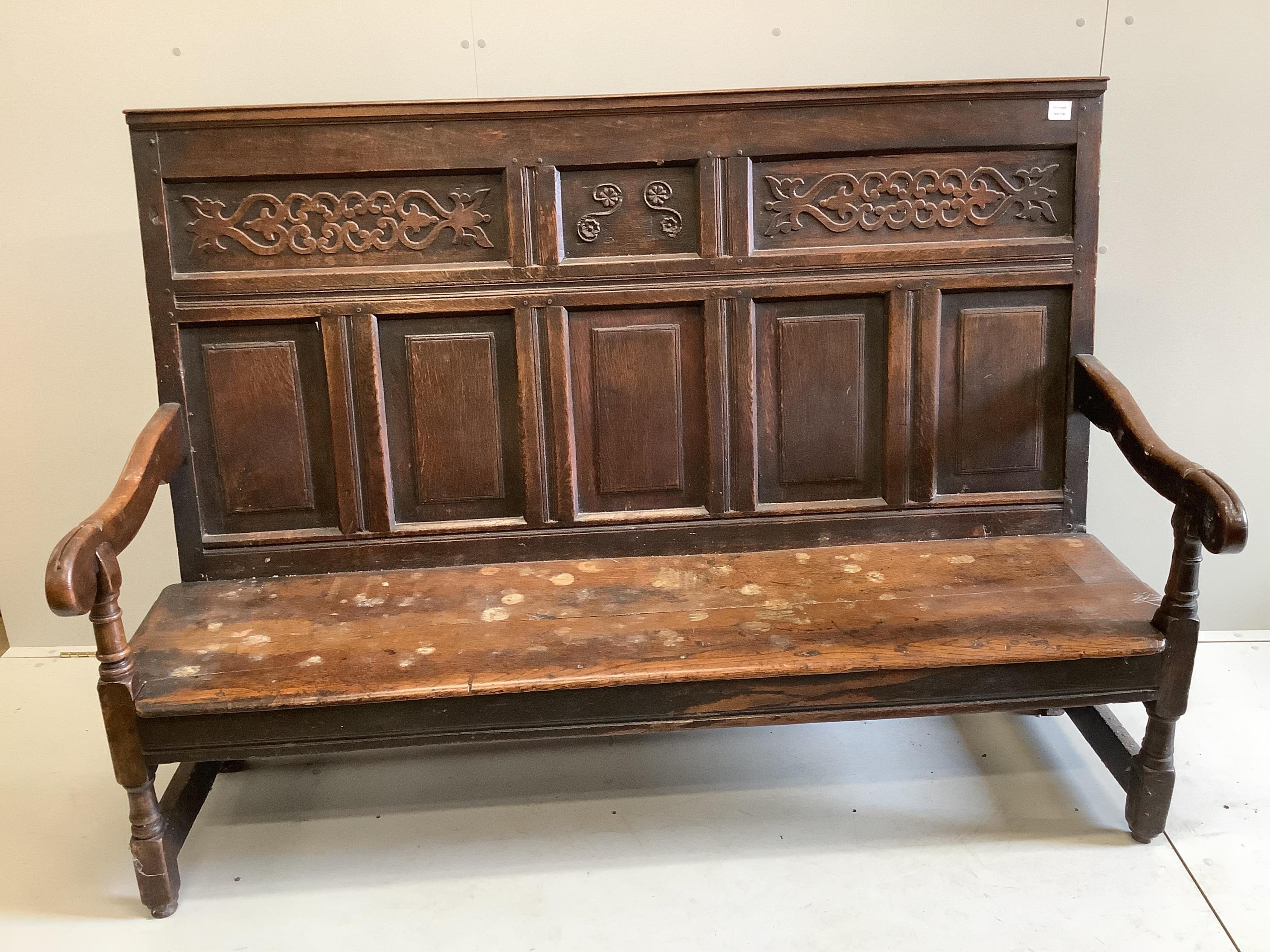 A mid 18th century carved oak settle, width 171cm, depth 58cm, height 122cm. Condition - poor to fair